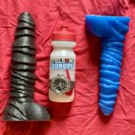 Two Hilts by Topped Toyed next to a lube bottle
