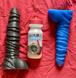 Two Hilts by Topped Toyed next to a lube bottle
